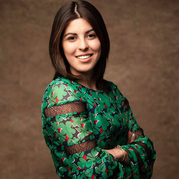 Licda. Stephanie Chandler, cabello corto, castaño, vestido verde, con los brazos cruzados mirando con una sonrisa hacia el frente